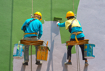 Professional painters painting a building wall in Dublin